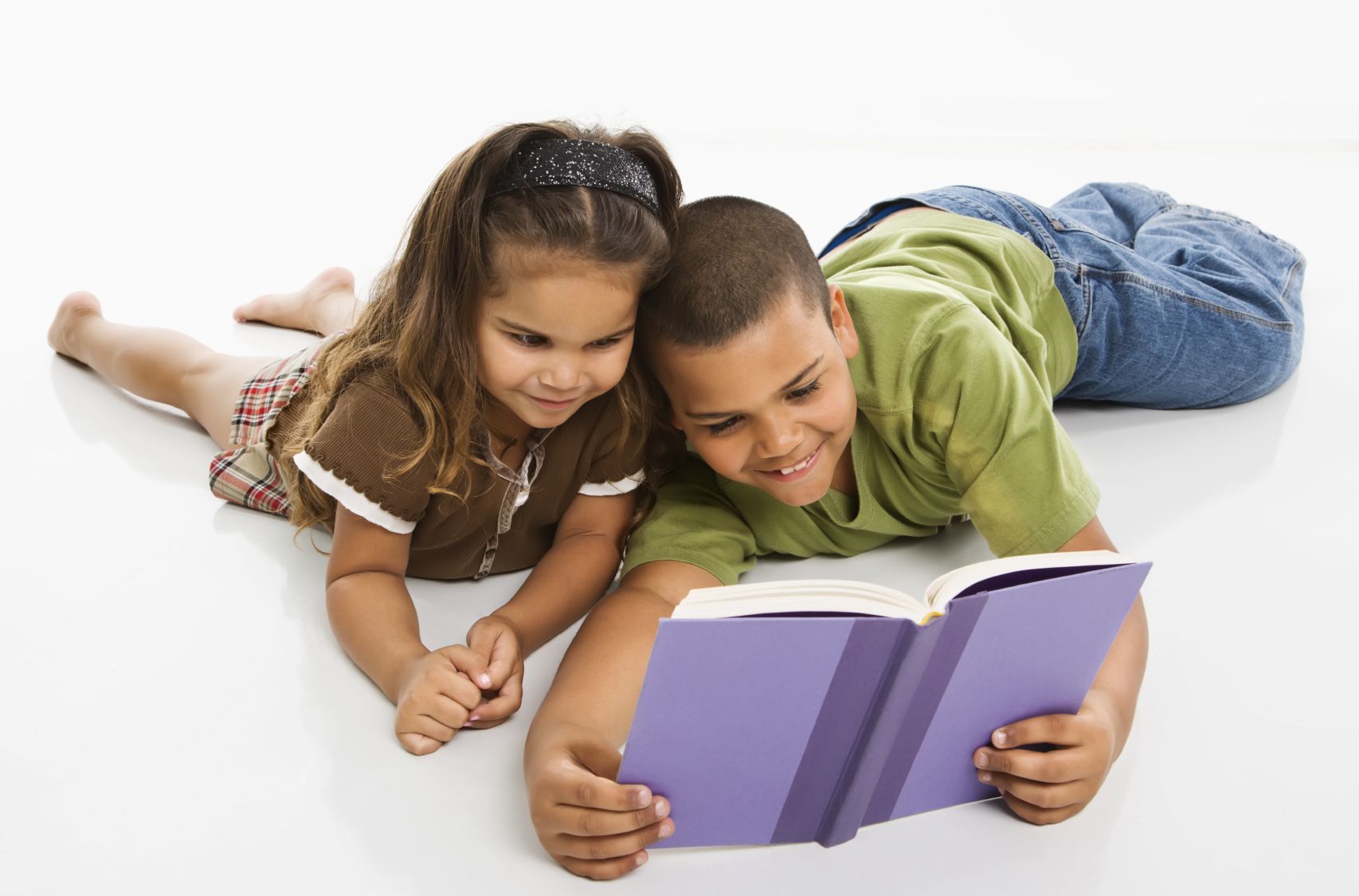 a young boy and a girl reading a book together