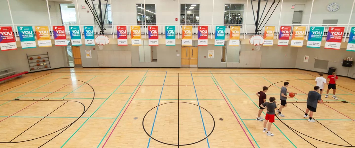 Gymnasium with 6 basketball hoops. Indoor track overhead.