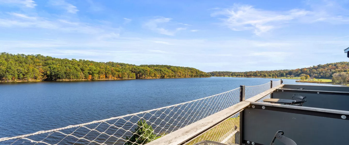 Private patio with two chairs overlooking Sunnen Lake outside Trout Lodge Room