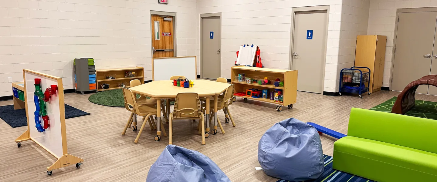 Bright and colorful renovated Child Watch room at East Belleville YMCA with bean bag chairs, play tables, and educational toys for kids.