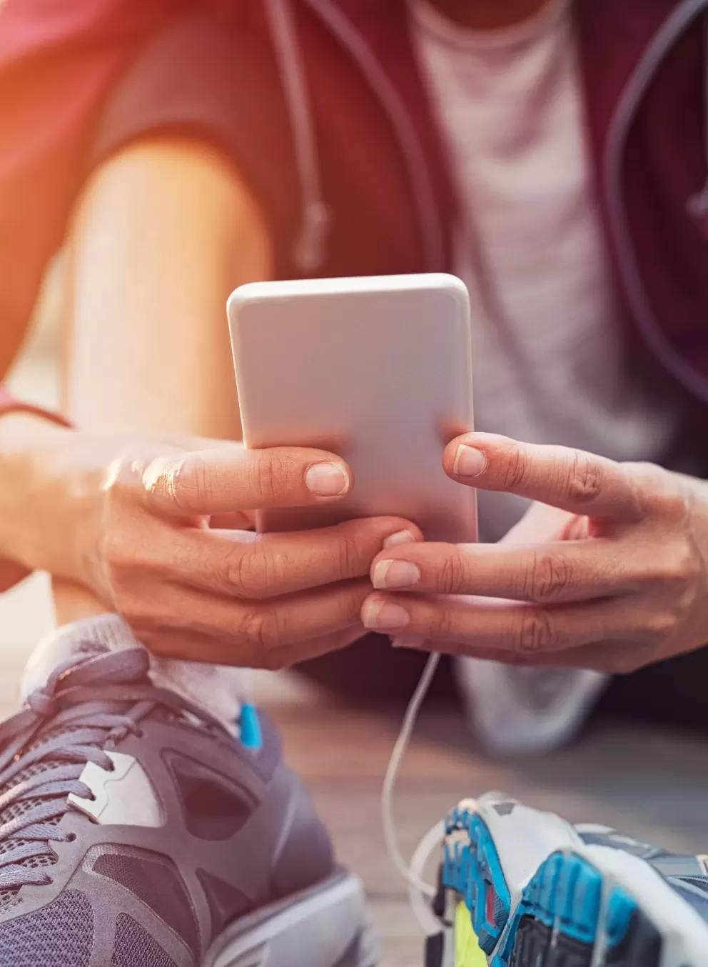 A person wearing workout clothes holding a cell phone