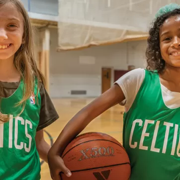 Two kids participating in a YMCA Youth Basketball League practice