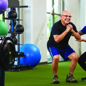 YMCA Exercise for Parkinson's Program participant works on balance with a ymca personal trainer