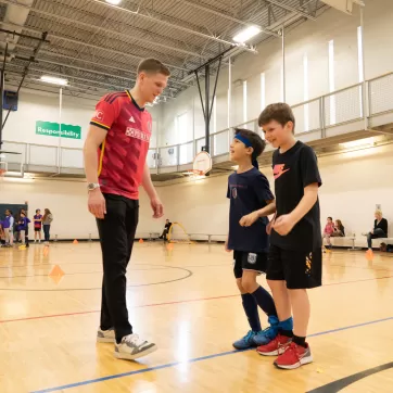 Joakim Nilsson, CITY SC defender, talks with two young YMCA soccer players