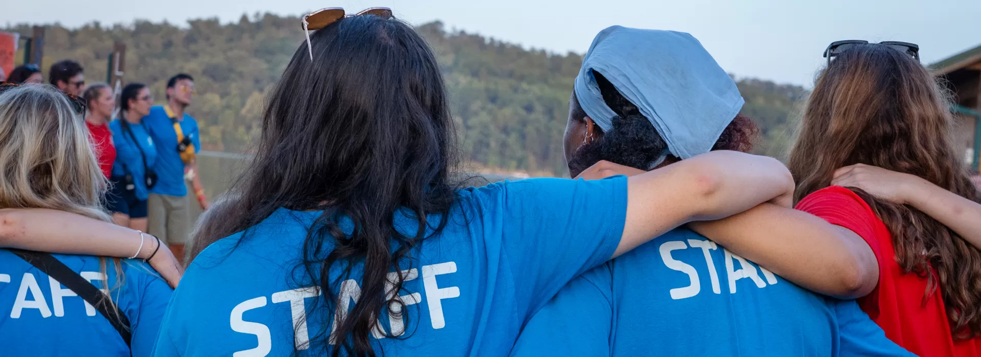 Arms around each other at campfire