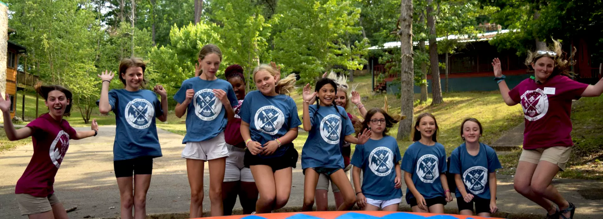ymca camp lakewood explorers girls jumping by canoe